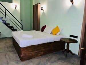 a bedroom with a bed with a table and stairs at ORENDA ECO LODGE & SPA in Galle