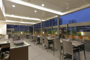 a restaurant with tables and chairs on a rooftop at Hotel Ariana Residency in Mumbai