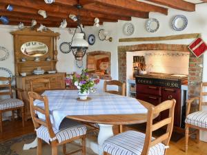 uma cozinha com uma mesa, cadeiras e um fogão em Southview Cottage em Newbridge