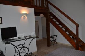 Zimmer mit einem Schreibtisch mit einem Computer und einer Treppe in der Unterkunft La Bergerie Du Cap in Cap d'Agde