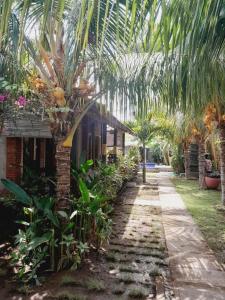 a garden with a palm tree and a house at La Paparrucha Bali in Pemuteran