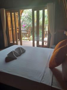 een bed met twee kussens erop bij La Paparrucha Bali in Pemuteran