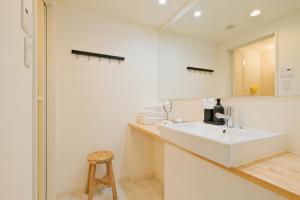 baño con lavabo blanco y taburete en Hotel FANDINA TOKYO -ファンディーナ東京-, en Tokio
