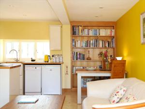 レナムにあるThe Hen House Cottageのリビングルーム(白いソファ付)、キッチンが備わります。