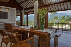 a dining room with a table with a vase of flowers at Palmterrace in Culik