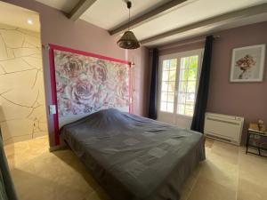 a bedroom with a bed and a painting on the wall at Le Cyprès de Casimir in Beaucaire