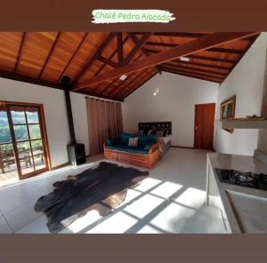a large living room with a bed and a stove at Lumiar Eco Lodge - Chalé Pedra Riscada in Nova Friburgo