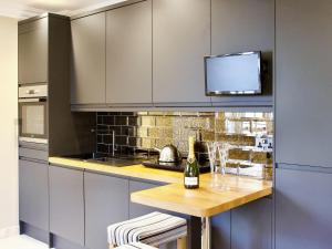 cocina con mesa y botella de vino en The White House Studio en Worthing