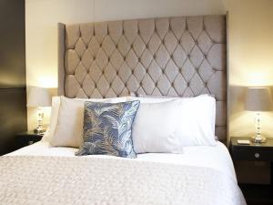 sypialnia z dużym białym łóżkiem z 2 lampami w obiekcie The White House Studio w mieście Worthing