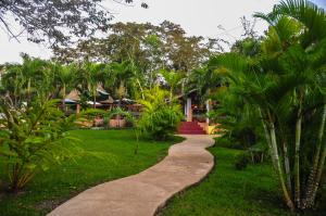 un passaggio pedonale di fronte a una casa con palme di The Log Cab-Inn a San Ignacio