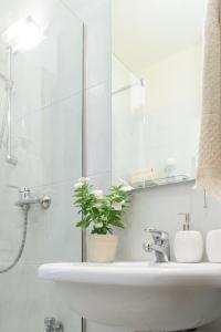 uma casa de banho branca com um lavatório e um chuveiro em Appartamento Fanciullacci em Montelupo Fiorentino