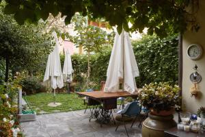 - une table avec des parasols blancs dans le jardin dans l'établissement Appartamento Fanciullacci, à Montelupo Fiorentino
