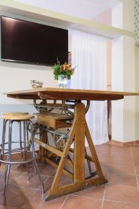Elle comprend une grande table en bois et une télévision murale. dans l'établissement Appartamento Fanciullacci, à Montelupo Fiorentino