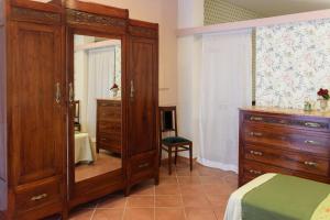 a bedroom with a large wooden dresser and a mirror at Appartamento Fanciullacci in Montelupo Fiorentino