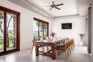 uma sala de jantar com mesa, cadeiras e janelas em Pidoma Resort em Sen Monorom