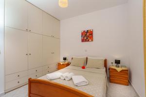 克拉托卡波斯的住宿－Hara's Apartment 1，一间卧室配有一张带白色橱柜的床。
