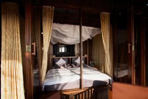 阿贡达Dunhill Beach Resort的卧室里有一张带白色床单的四柱床
