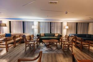 a waiting room with chairs and a couch and tables at Palmon Bay Hotel & Spa in Herceg-Novi