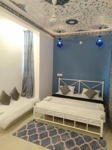 a bedroom with a white bed and blue walls at Full View Villa in Udaipur