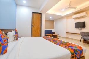 a bedroom with a bed and a flat screen tv at FabHotel Blue Marine in Indore