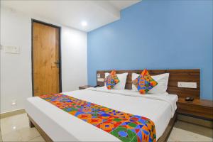a bedroom with a large bed with a colorful blanket at FabHotel Blue Marine in Indore