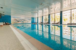 a swimming pool in a building with blue walls and windows at Palmon Bay Hotel & Spa in Herceg-Novi
