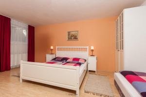 una camera con due letti e tende rosse di Haus Ruth a Obsteig