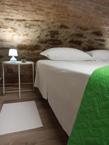 a bedroom with a bed and a table with a lamp at Matalena in Pomarico