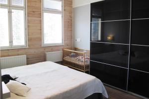 1 dormitorio con cama blanca y pared negra en Large Family Apartment UNELMA - Tahko, Palju, BBQ, Sauna, WiFI, PetsOK, Budget, Wanha Koulu Tahkovuori, en Reittiö