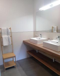 a bathroom with two sinks and a mirror and a chair at Appartement Heimatliebe in Schladming
