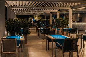 un comedor con mesas y sillas azules en Palmon Bay Hotel & Spa, en Herceg-Novi