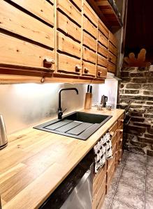 een keuken met een wastafel en houten kasten bij Villa Saarua by the Slopes Ski in, Family & Bike Park, hike trails, National Park, WiFi - Lapland Villas in Ruka