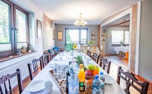 een eetkamer met een lange tafel en stoelen bij Weekend house w lesie, na Kaszubach in Rybaki