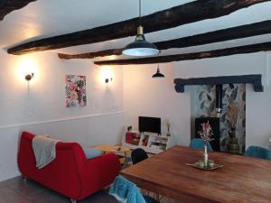 a living room with a red chair and a table at Maison atypique et charmante in Pleugueneuc