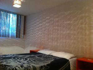 a bedroom with a bed with a zebra patterned wall at Hotel Centro Diana in Mexico City