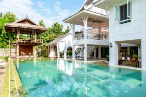 ein Bild einer Villa mit einem Pool in der Unterkunft Phi Private Villa: Luxury Thai with Riverview in Chiang Mai