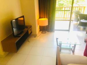 a living room with a tv and a table at 3 room apartment with garden view in Banting