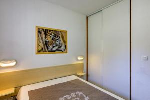 a bedroom with a bed and a painting of a tiger at Le Val 1800 - Appartement avec Terrasse in Valmeinier