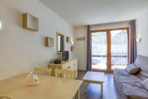 een woonkamer met een bank en een tafel bij Le Val 1800 - Appartement avec Terrasse in Valmeinier