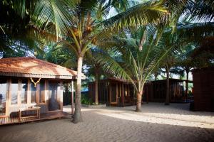 a couple of palm trees next to a building at Dunhill Beach Resort in Agonda