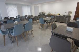 a dining room with tables and chairs and a kitchen at Lileo Inn Hotel in Mestia