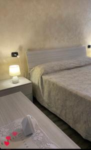 a bedroom with two beds and a table with a lamp at Casa Anita in Naples