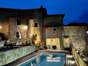 a villa with a swimming pool in front of a building at Villa Borgo Soale in Reggello