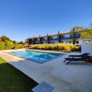 a swimming pool in front of a building at SE7EVILAS - JustZen in Pêra