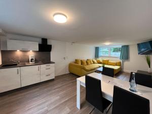 cocina y sala de estar con sofá amarillo en Gästehaus Blauth en Cuxhaven