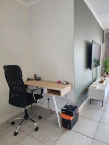 an office with a desk and a chair in a room at Loadshedding Equipped 2-Bed Apartment in Waterfall, Waterfall City in Midrand
