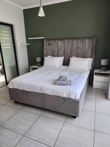 a bedroom with a large bed with a towel on it at Loadshedding Equipped 2-Bed Apartment in Waterfall, Waterfall City in Midrand
