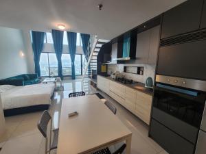 ジョージタウンにあるSunrise Gurney Premium Suite - Gurney Driveのベッド1台付きの部屋、テーブル付きのキッチンが備わる客室です。