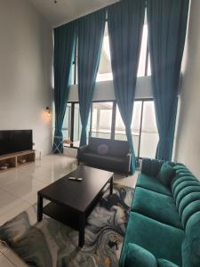 a living room with a green couch and a table at Sunrise Gurney Premium Suite - Gurney Drive in George Town