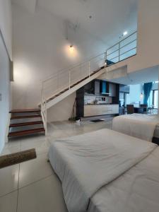 a bedroom with two beds and a staircase at Sunrise Gurney Premium Suite - Gurney Drive in George Town